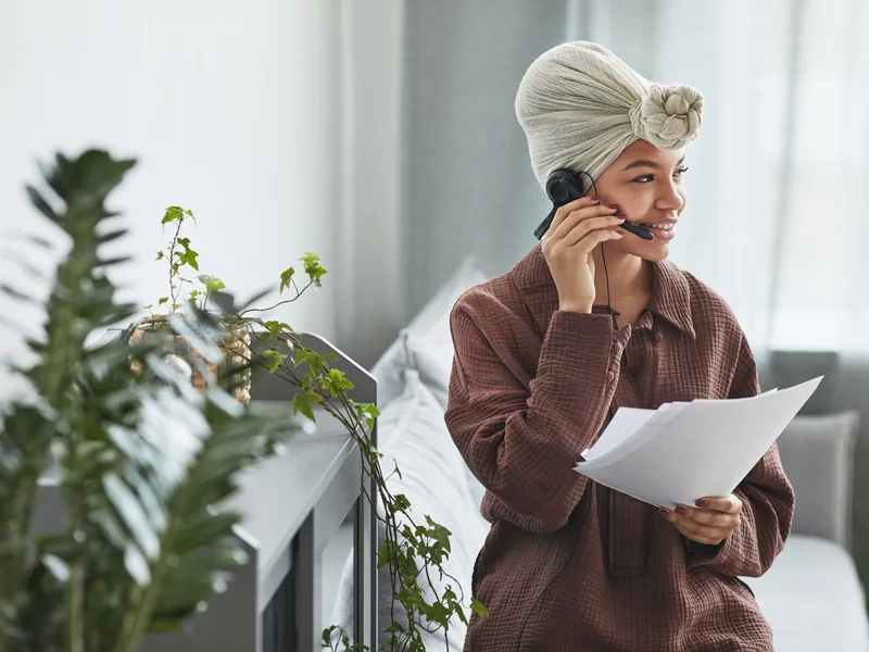 A support agent wearing a headset and reviewing documents.